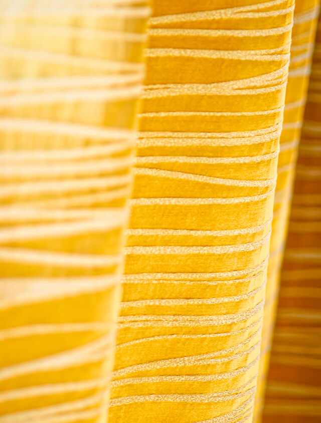 Close-up of custom-made golden striped curtains from premium manufacturer Zimmer & Rohde with elegant horizontal stripe pattern in warm gold tones in furnished apartment Bamberg