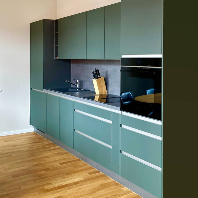 Modern Nobilia kitchen in mineral green ultra-matte with easy-care Easytouch surface, aluminum handles and edges, integrated Siemens oven on oak parquet in furnished apartment Bamberg