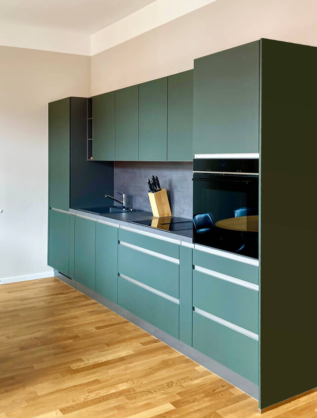 Modern Nobilia kitchen in mineral green ultra-matte with easy-care Easytouch surface, aluminum handles and edges, integrated Siemens oven on oak parquet in furnished apartment Bamberg